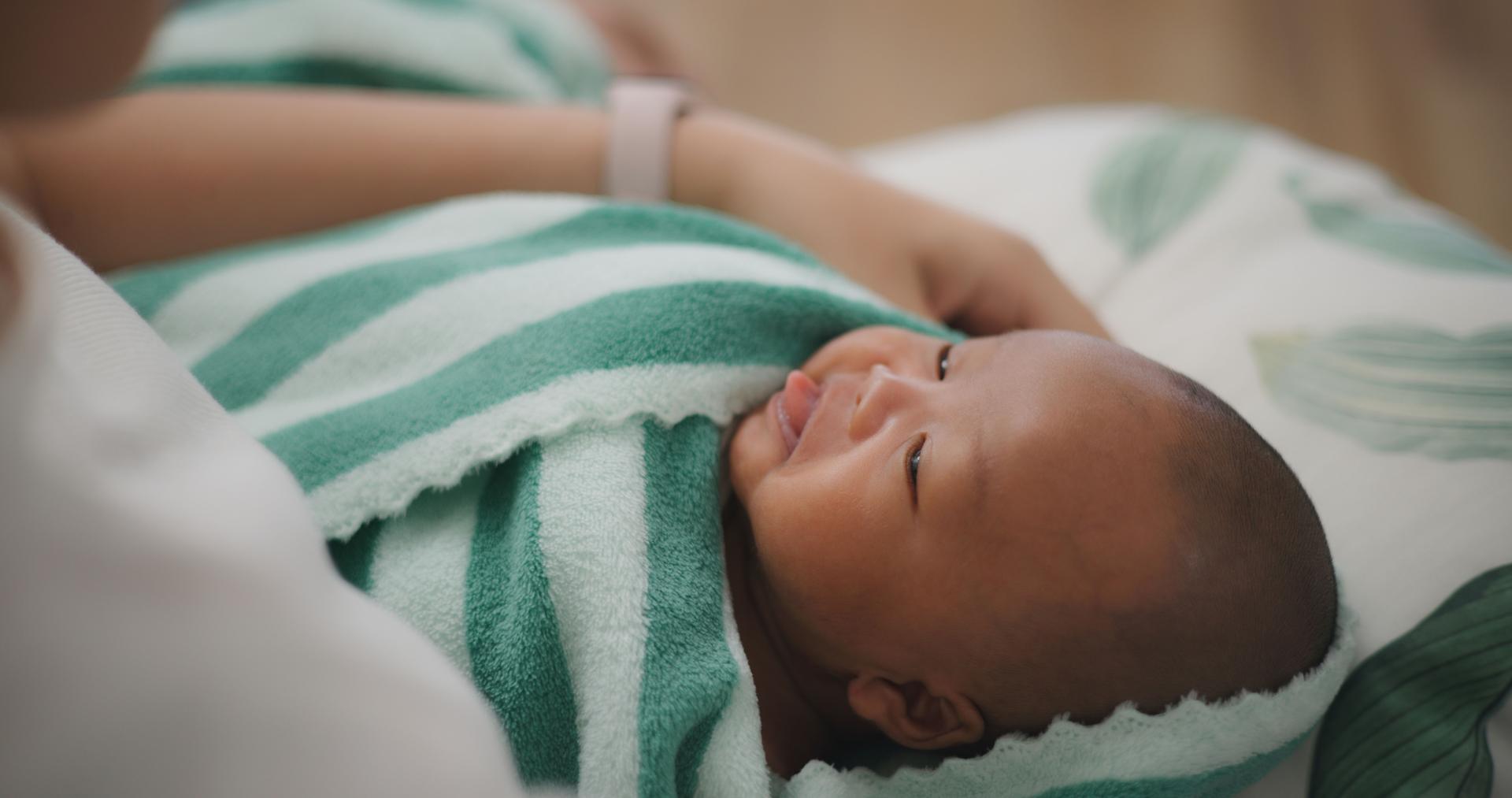 Young asian mother holding newborn in arms Rocking for baby to sleep